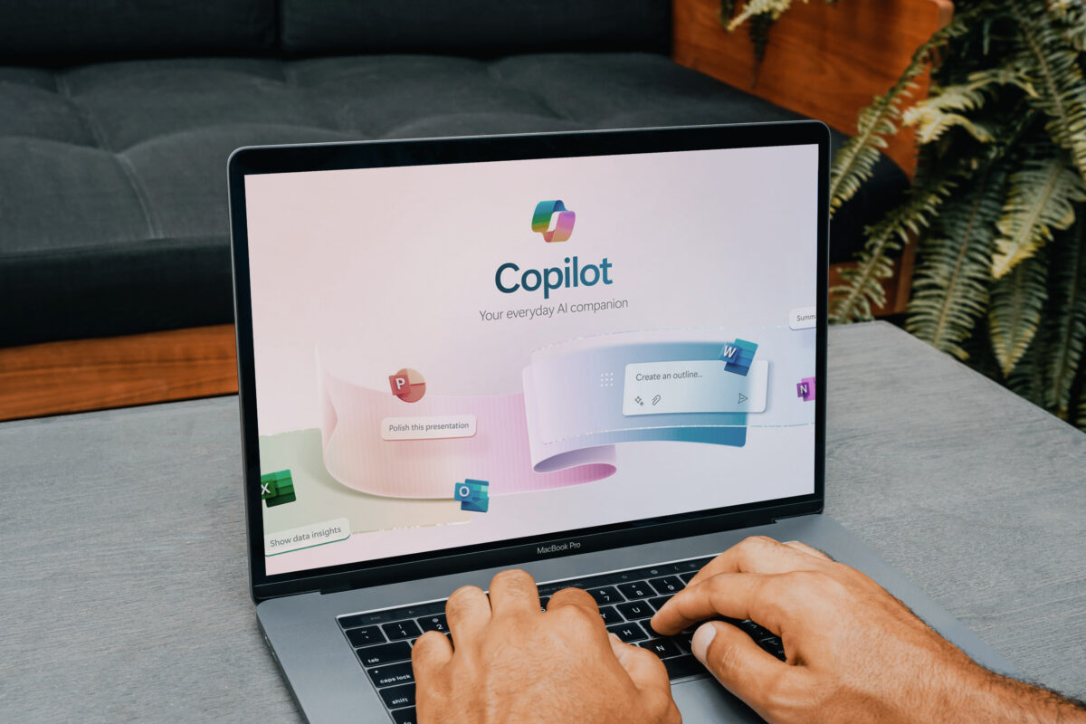 Laptop mit geöffneter Microsoft Copilot-Anwendung. KI-gestützte Funktionen für Word, Excel, PowerPoint und Outlook werden angezeigt