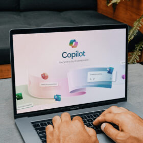 Laptop mit geöffneter Microsoft Copilot-Anwendung. KI-gestützte Funktionen für Word, Excel, PowerPoint und Outlook werden angezeigt